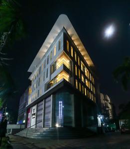 un grand bâtiment la nuit avec la lune derrière lui dans l'établissement Delta Suites, à Durgapur