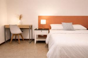 a bedroom with a bed and a desk and a chair at La Maison d'Isa in Albion