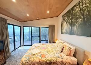 a bedroom with a bed and a large painting on the wall at Serendeva: Stunning views, private & EV charger in Denmark