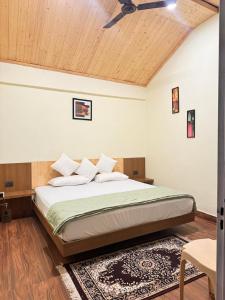 a bedroom with a bed with a ceiling fan at Shivay Hotel & Resort in Dhārchula