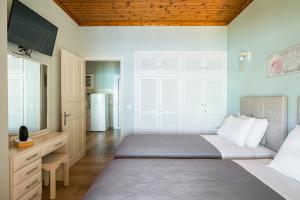 a bedroom with a bed with a television and a refrigerator at Baracunda Seaview Apartments with private Hot Tub by Konnect in Barbati +5 photos
