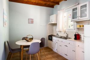 a kitchen with a table and chairs and a sink at Baracunda Seaview Apartments with private Hot Tub by Konnect in Barbati