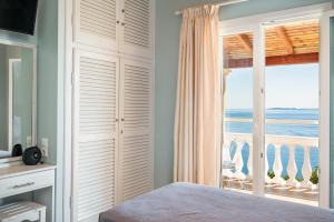 a bedroom with a bed and a view of the ocean at Baracunda Seaview Apartments with private Hot Tub by Konnect in Barbati