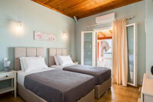 a bedroom with two beds and a window at Baracunda Seaview Apartments with private Hot Tub by Konnect in Barbati