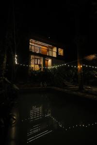 a building at night with a pool in front of it at HoneyStone Resort in Sultan Bathery