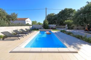 ein Swimmingpool in einem Hinterhof mit Liegestühlen drumherum in der Unterkunft Antona in Šibenik