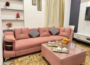 a pink couch in a living room with a table at Sagar Villa Udaipur in Udaipur