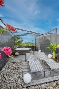 a deck with two chairs and some flowers at The Lima Ocean Suites Pererenan in Canggu +36 photos