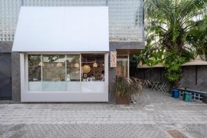a white facade of a building with a storefront at The Lima Ocean Suites Pererenan in Canggu