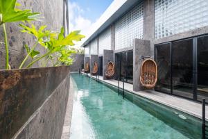 a swimming pool in the middle of a building at The Lima Ocean Suites Pererenan in Canggu