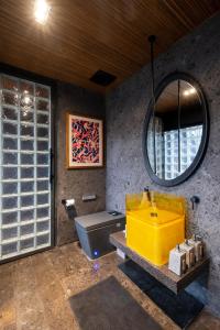 a bathroom with a yellow sink and a mirror at The Lima Ocean Suites Pererenan in Canggu