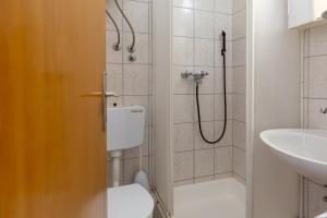 a bathroom with a shower and a toilet and a sink at Tinka, Zimmer No 2 in Starigrad