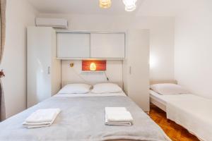 two beds in a room with white walls at Tinka, Zimmer No 3 in Starigrad