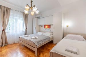 a bedroom with two beds and a chandelier at Tinka, Zimmer No 3 in Starigrad