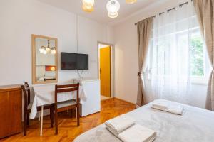 a bedroom with a desk and a bed and a table at Tinka, Zimmer No 3 in Starigrad +7 photos