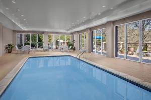 a swimming pool in a house with a large room with windows at Hampton Inn & Suites Clinton in Clinton