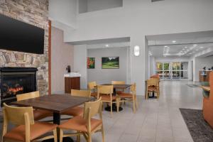 a dining room with a fireplace and a table and chairs at Hampton Inn & Suites Clinton in Clinton
