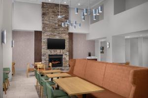 a lobby with a couch and tables and a fireplace at Hampton Inn & Suites Clinton in Clinton