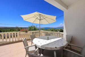 a white table with an umbrella on a balcony at Antonija in Bašić