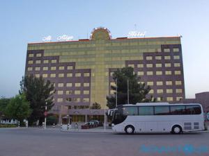 a bus parked in a parking lot in front of a building at Ak Altyn in Ashgabat