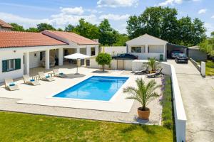 a backyard with a swimming pool and a house at Holiday house Luca with private pool in Vrsi