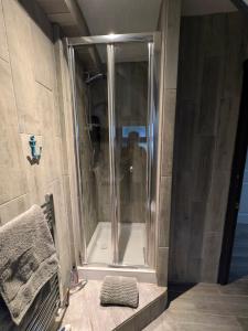 a shower with a glass door in a bathroom at White Pebbles Appartment in Ilfracombe +22 photos