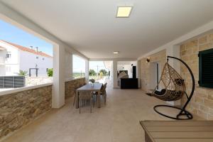 a living room with a table and a chair at Holiday house Luca with private pool in Vrsi
