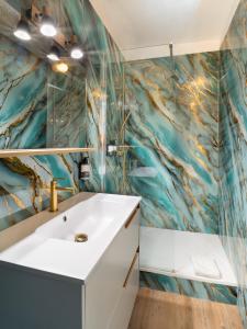 a bathroom with a white sink and a blue wall at Hôtel de la Mer in Hyères +134 photos