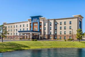 an office building with a river in front of it at Hampton Inn & Suites Claremore in Claremore