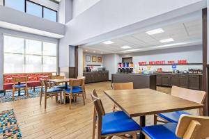 a dining room with tables and chairs and a cafeteria at Hampton Inn & Suites Claremore in Claremore