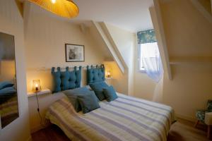a bedroom with a large bed with a blue headboard at La Villa Port Winston - Face Mer Chambres & Studios in Saint-Côme-de-Fresné