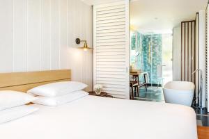 a bedroom with a white bed and a table at Park Hyatt St. Kitts in Christophe Harbour +139 photos