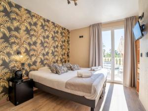a bedroom with a bed with a yellow and gold wallpaper at Hôtel de la Mer in Hyères