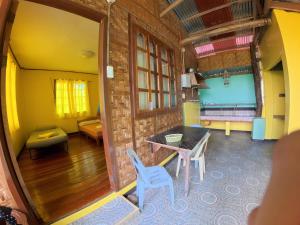 a room with a table and chairs and a couch at Xylla Guesthouse in Ytaya