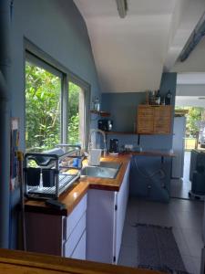 a kitchen with a sink and a window in it at Fare Te Ava Iti in Teahupoo