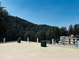 a patio with a fence with trees in the background at JB Hotel and Resort in Lohaghāt
