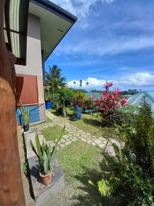 a garden outside a house with a view of the ocean at Fare Te Ava Iti in Teahupoo