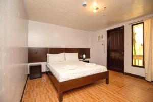 a bedroom with a large bed with a wooden headboard at Palette Boracay Isle by The White Beach in Boracay