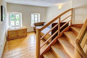 a staircase in a room with wooden floors and windows at Nengshof Ferienhaus Königskerze in Wißmannsdorf +30 photos
