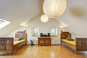 a attic bedroom with two beds and a desk at Nengshof Ferienhaus Königskerze in Wißmannsdorf
