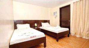 a hotel room with two beds and a window at Palette Boracay Isle by The White Beach in Boracay