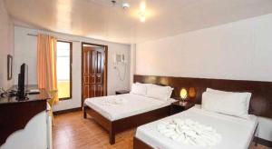a hotel room with two beds and a television at Palette Boracay Isle by The White Beach in Boracay