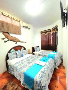 a bedroom with two beds and a bird on the wall at Casa Galarous Island in Puerto Ayora +66 photos
