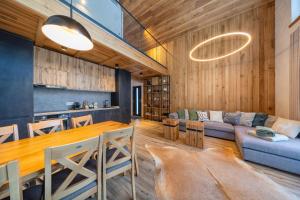 a kitchen and living room with a table and a couch at Vama Chalet in Vama Buzăului