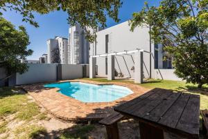 a swimming pool in a yard with a picnic table at The Sands Cottage in Cape Town