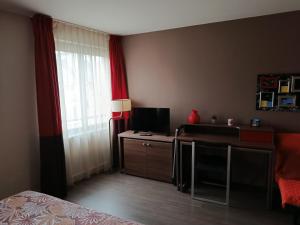 a hotel room with a desk and a window at Studio au-dessus de l'Orne in Caen