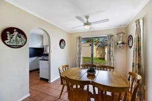 a kitchen and dining room with a wooden table and chairs at Fravent house in Toukley