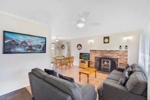 a living room with two couches and a fireplace at Fravent house in Toukley