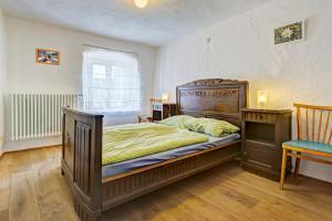 a bedroom with a large wooden bed and a chair at Nengshof Ferienhaus Ehrenpreis in Wißmannsdorf