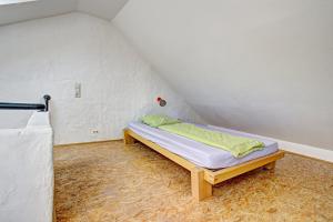 a small room with a bed in a attic at Nengshof Ferienhaus Ehrenpreis in Wißmannsdorf +21 photos